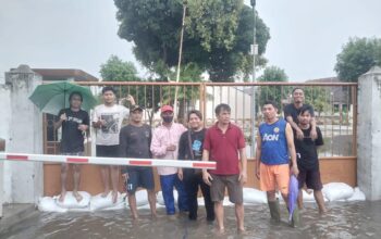 Sejumlah warga Mekar Sari saat berusaha menghambat aliran air dari Rumah Sakit Sitanala